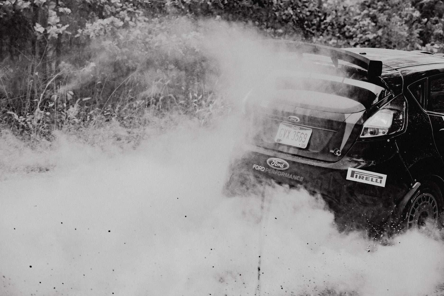 Black and white rally car in dust
