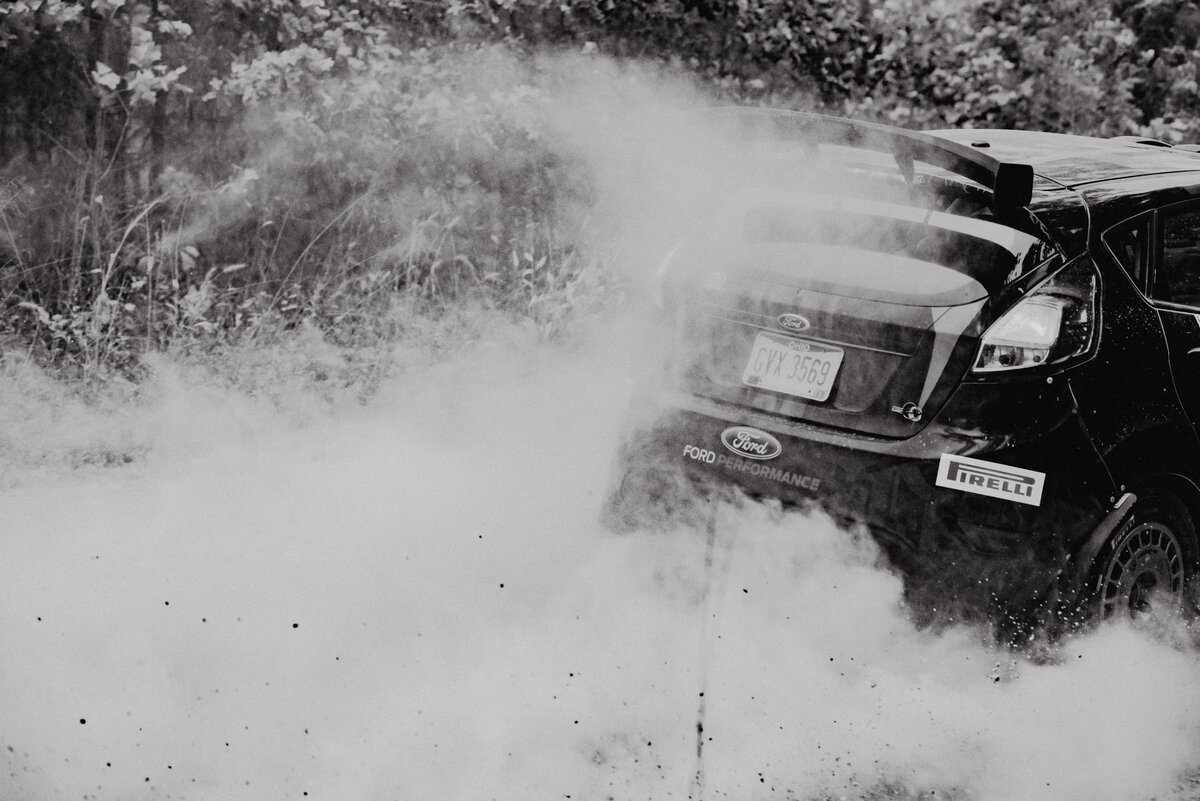 Black and white rally car in dust